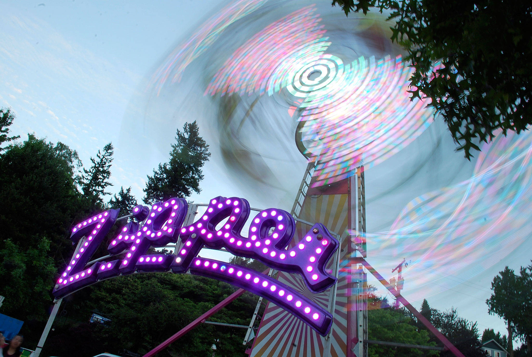 The Fathoms O’ Fun Carnival’s Zipper ride was awash in color as dusk fell on the Port Orchard waterfront. Photo: Bob Smith | Kitsap Daily News