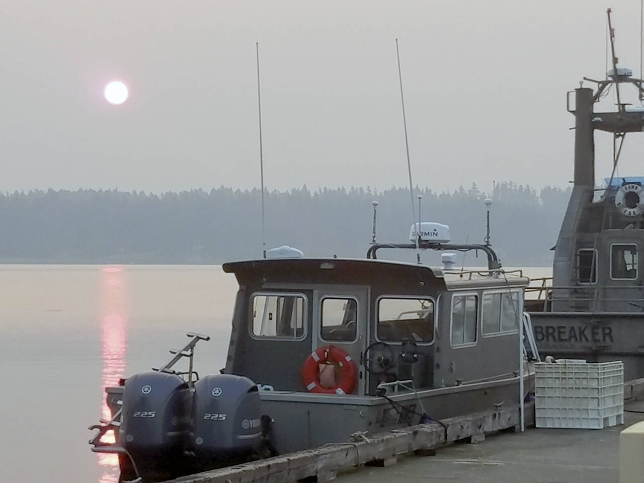 A blood-orange sun rises over Bainbridge Island the morning of Aug. 3 as fishing boats at Brownsville Marina await their crews. Ironically, the name of the boat on the right is “Dawn Breaker.” The colorful sunrise is due to the smoke from forest fires in Canada.                                Terryl Asla/Kitsap News Group