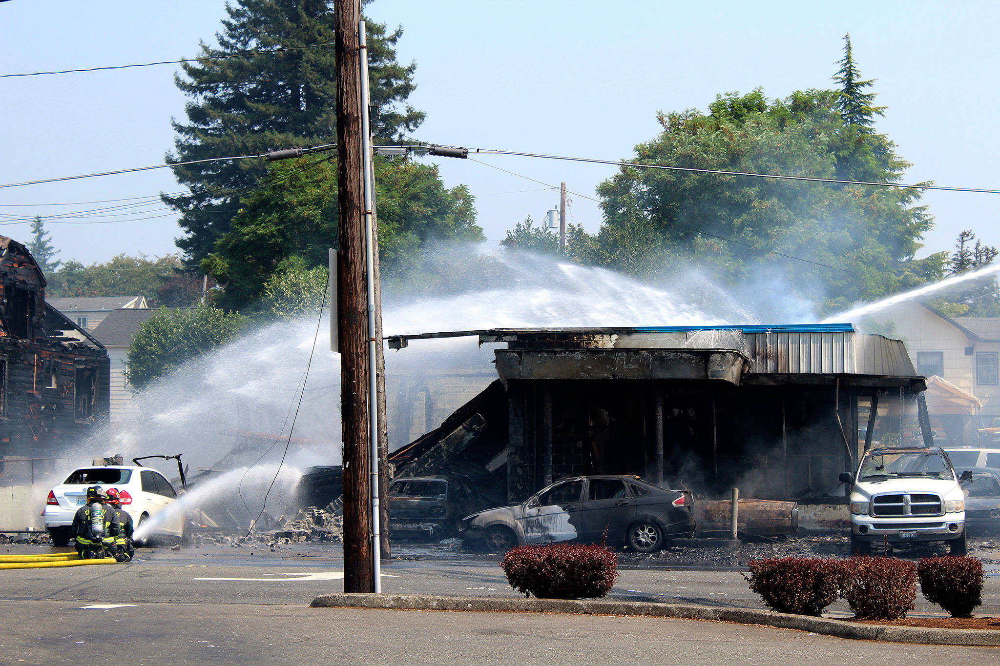 Crews from the Bremerton, South Kitsap, Central Kitsap and Navy Region Northwest fire departments work together to put out a two-alarm fire that started in Motor City Automotive, at the corner of North Callow Avenue and 11th Street, around 12:16 p.m. Aug. 3.                                Michelle Beahm / Kitsap News Group