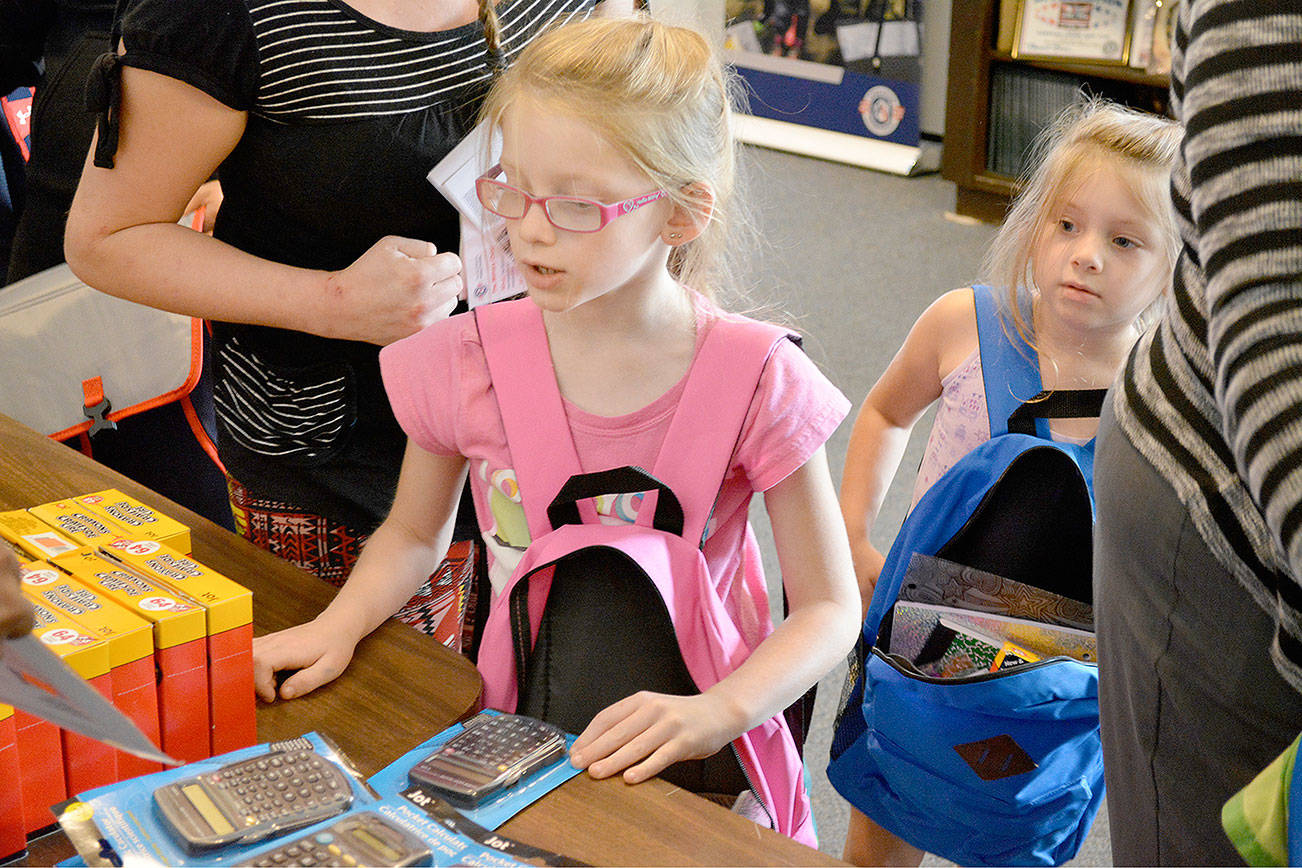 Kailey, 7, of Silverdale, looks over the items on the table during Operation Homefront’s annual Back-to-School Brigade. (Mark Krulish/Kitsap News Group)