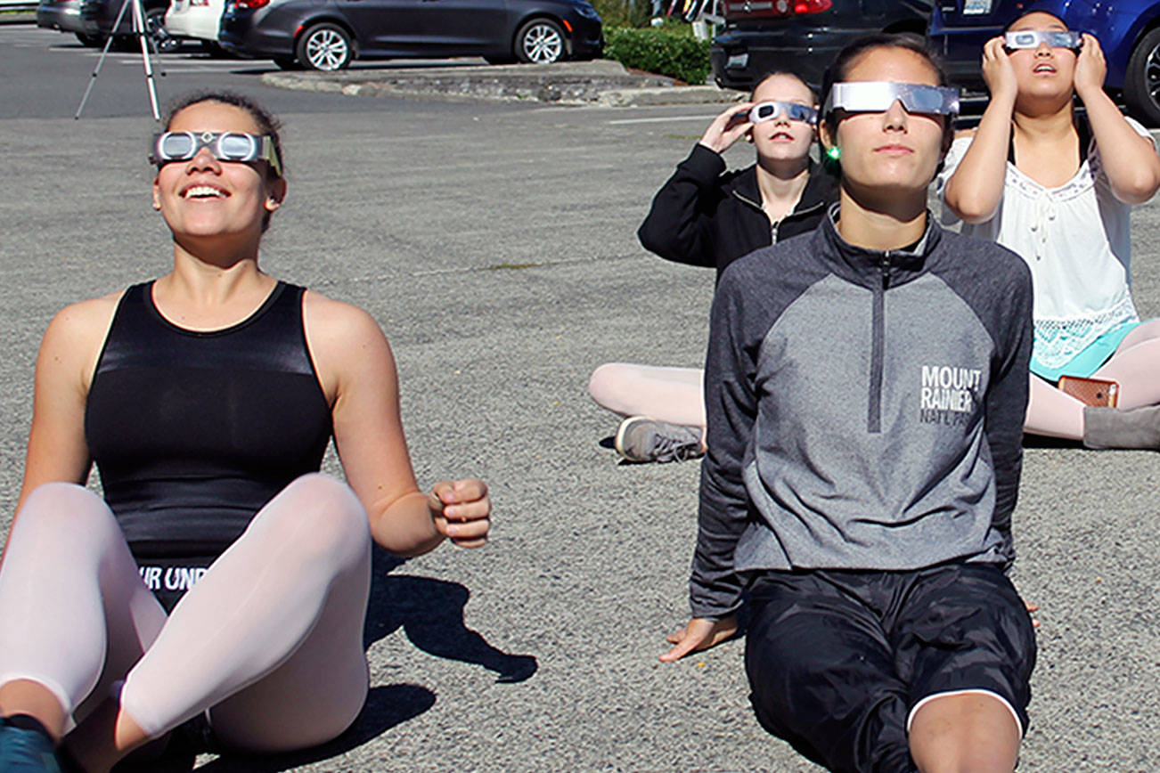 Dancers from Galletta School of Dance pause from practice to watch the eclipse, Aug. 21. From left, Keilah Andrews, Suquamish; Emmalia Monroe, Bainbridge Island; Riis Williams, Poulsbo; and Sachiko Miyoshi, Poulsbo. (Richard Walker/Kitsap News Group)