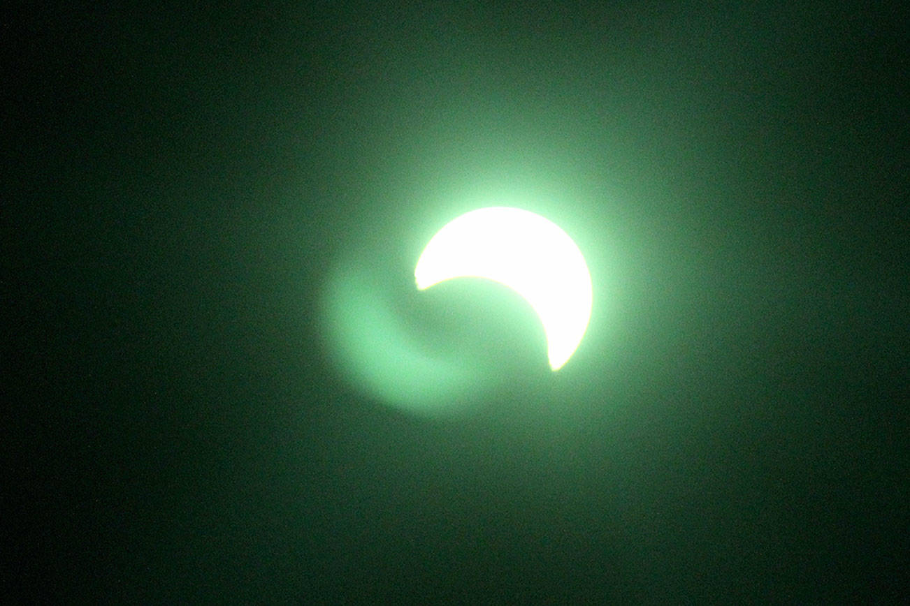 The solar eclipse, viewed through welder’s glass, which gave the sight a green tint.                                Michelle Beahm / Kitsap News Group