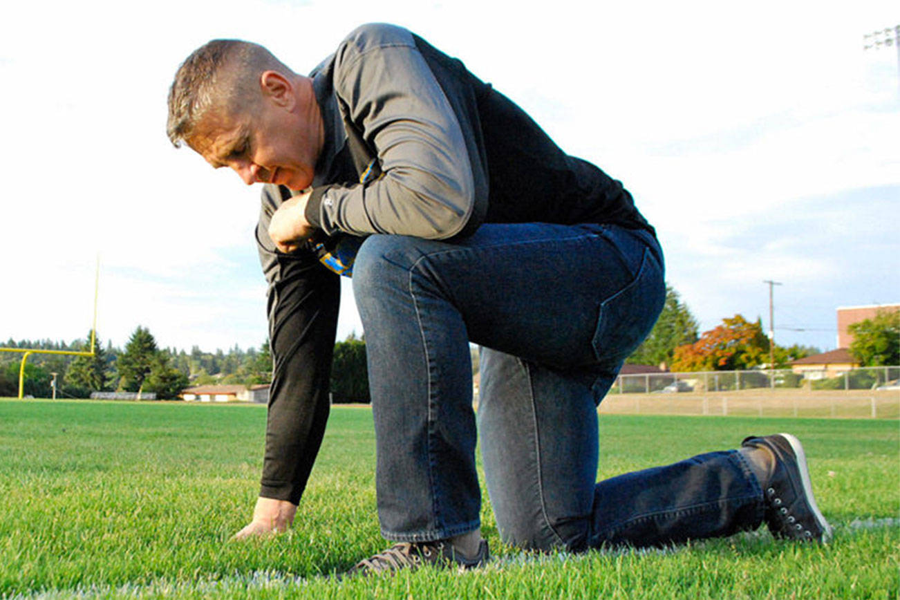 Former Bremerton High School football coach Joe Kennedy kneels on the 50-yard line of a football field in prayer in this photo provided in June by First Liberty Institute.