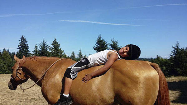 Devon Tom, Port Gamble S’Klallam, relaxes with Joey, a stallion, at Lynne Ferguson’s Native Horsemanship Youth Program. (Courtesy photo)