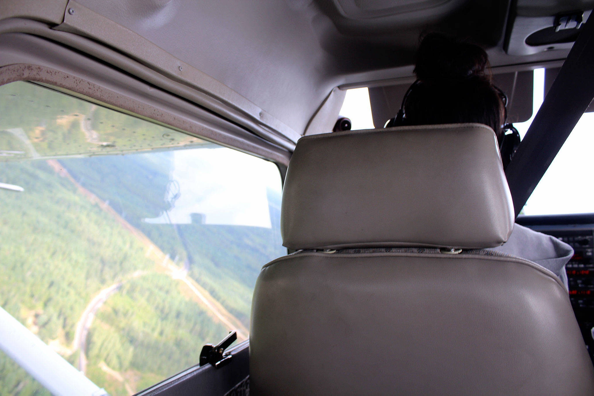 Mikela Arnall, 14, makes a sharp left turn while piloting a small plane under the direction of pilot Mary Suligoy.                                Michelle Beahm / Kitsap News Group