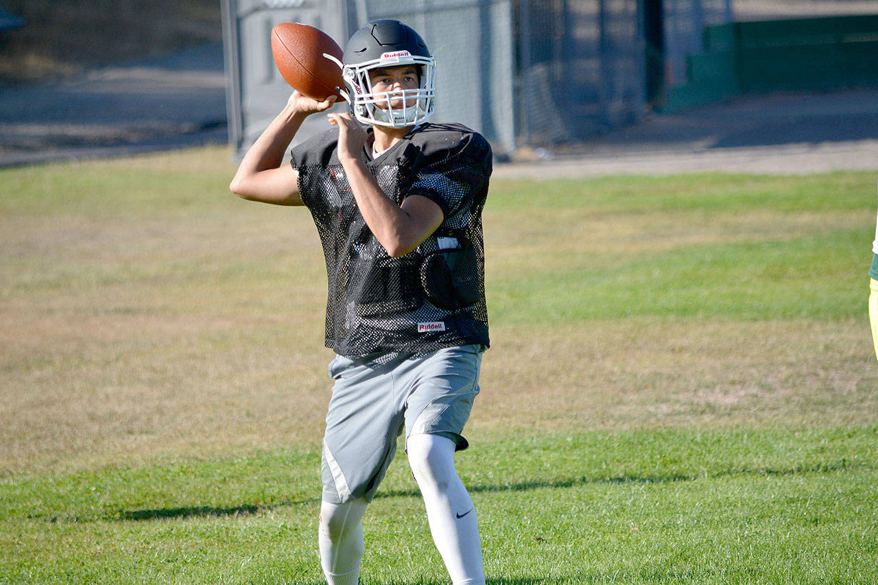 Klahowya quarterback John Hartford passes over a defender during a late- August practice.                                 Mark Krulish/Kitsap News Group