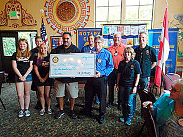 Representatives of the South Kitsap High School marching band accept a $6,500 donation from the Rotary Club of South Kitsap at the organization’s Aug. 29 meeting. Photo: Rotary Club of South Kitsap photo