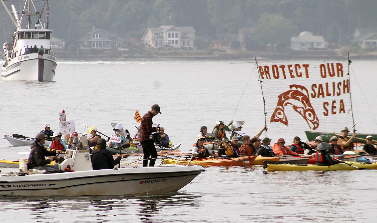 Protesters honk, chant and wave signs for the television camera boat.                                 Terryl Asla/Kitsap News Group