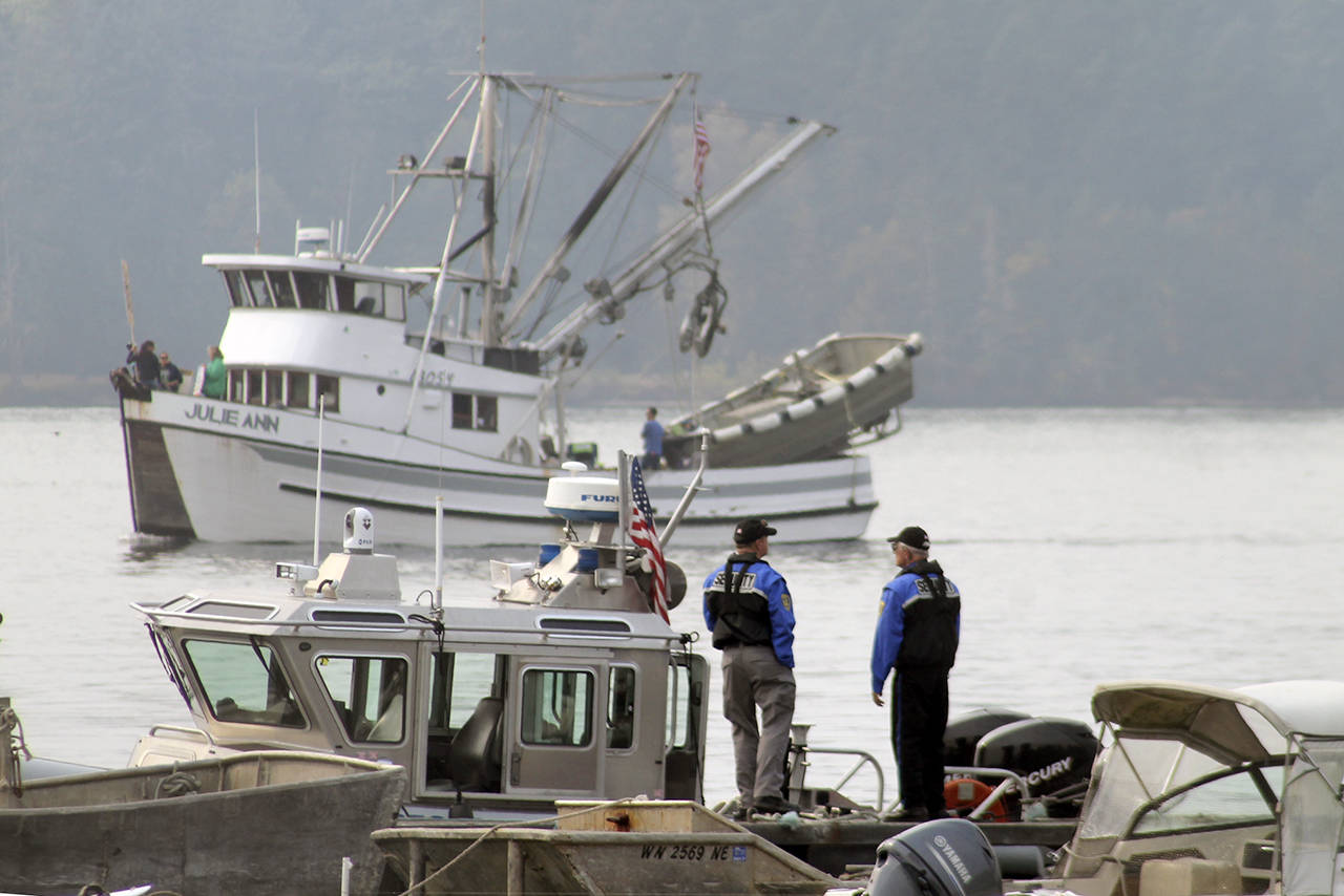 Security guards watch as one the motorized vessels enters the wide channel between the wharf building and the off-shore fish pens.                                Terryl Asla/Kitsap News Group