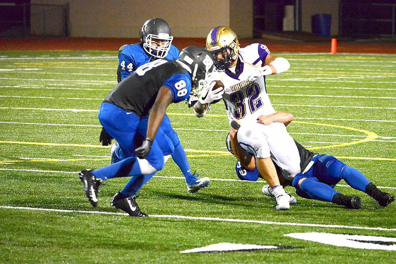 North Kitsap running back Dax Solis (32) takes on three Olympic defenders during his team’s 49-6 league win on Sept. 21. (Mark Krulish/Kitsap News Group)