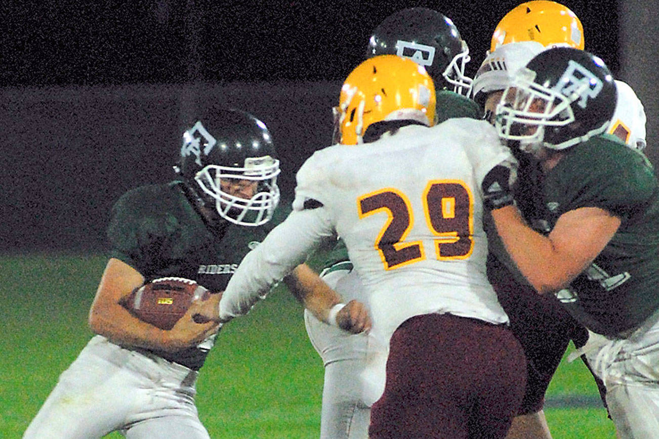 Port Angeles’ Jarret Burns, left, looks for an opening against Kingston during the first quarter on Sept. 29 in Port Angeles. (Keith Thorpe/Peninsula Daily News)