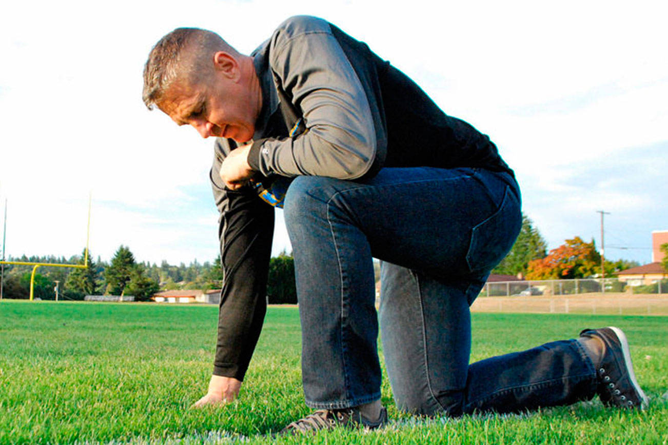 Joe Kennedy kneels on the 50-yard line of a football field in prayer in a photograph provided the Liberty Institute. Kennedy and his lawyers filed a petition Sept. 21 requesting that his case be considered by the entire circuit court — 11 judges, including the chief judge.