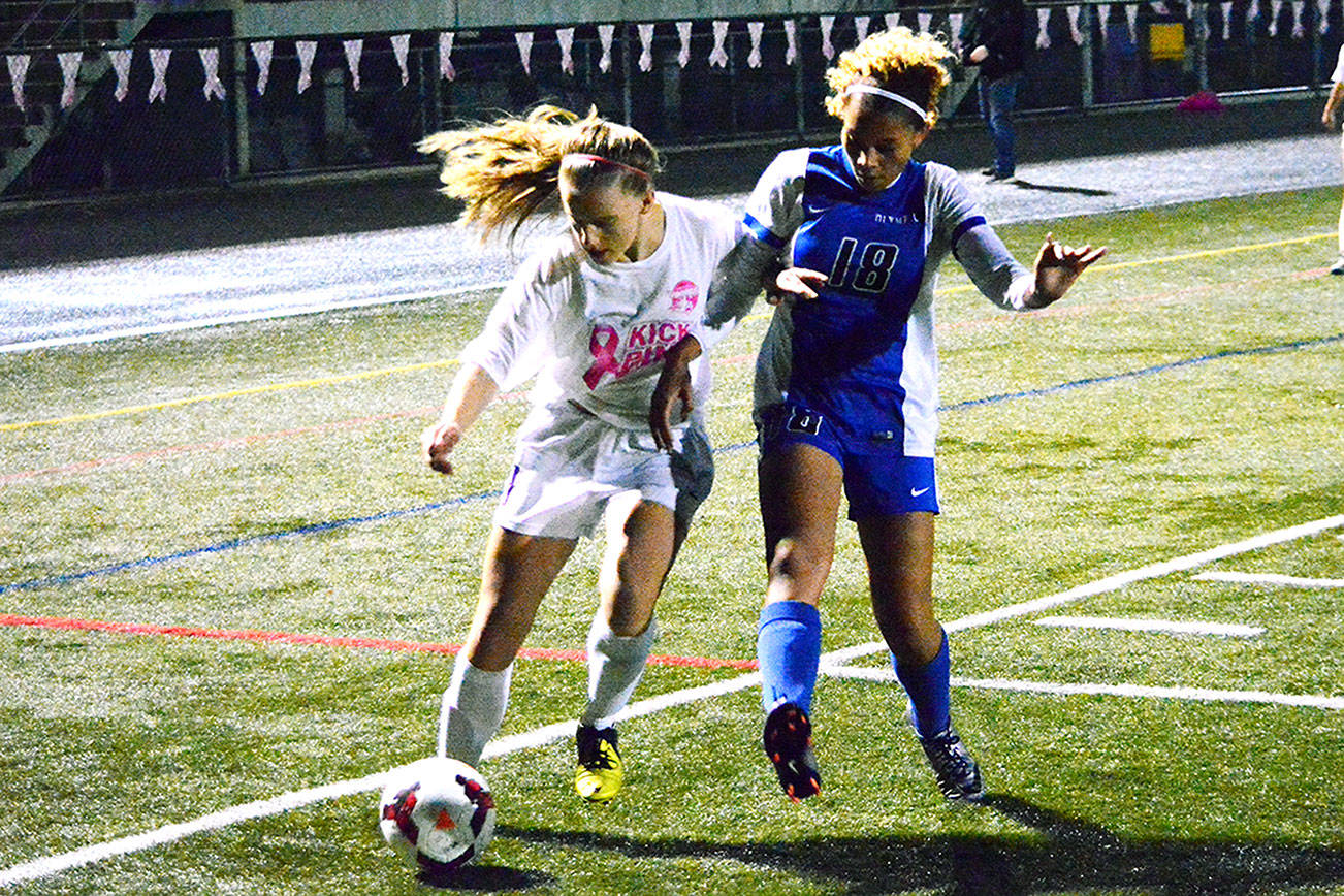 North Kitsap’s Abigail Ginn and Olympic’s Saoirse Brown (18) fight for the ball during the second half of the Vikings’ 2-1 victory over the Trojans. (Mark Krulish/Kitsap News Group)