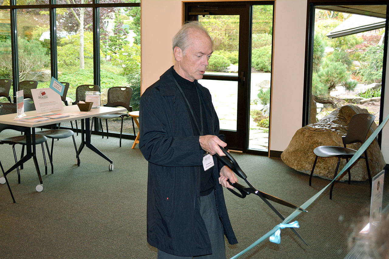 Eric Petersen, Bainbridge Public Library Board President, cuts the ribbon on the newly-remodeled library on Oct. 14. (Mark Krulish/Kitsap News Group)