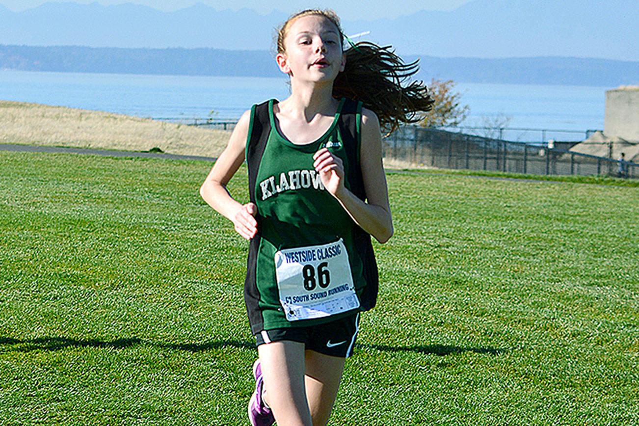Left, Rachel Newhard leads the pack at Chambers Bay on Oct. 28. She captured Klahowya’s first individual district championship in over a decade. Right, Lucas Becker crosses the finish line in fourth place at the West Central District meet.                                Mark Krulish/Kitsap News Group