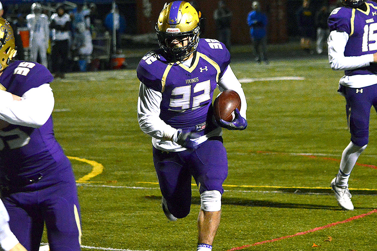 North Kitsap running back Dax Solis (32) runs past the blocks of his teammates during the Vikings’ district playoff win over Eatonville.