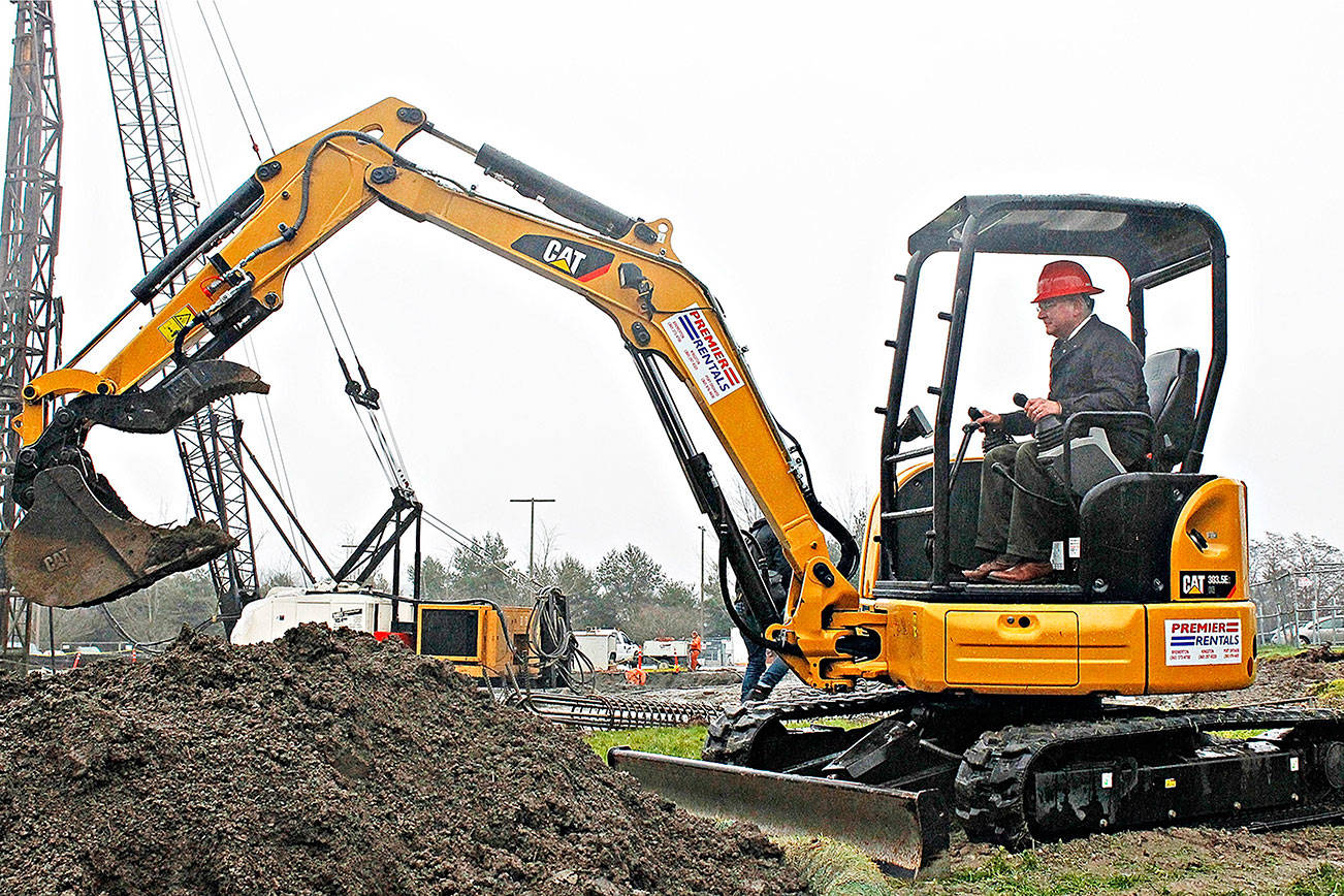 David Mitchell, current Olympic College president, uses a loader instead of a shovel at the ceremonial groundbreaking for the school’s new College Instruction Center groundbreaking ceremony Dec. 17, 2015. Mitchell retires Dec. 31, 2017.                                Michelle Beahm / File photo