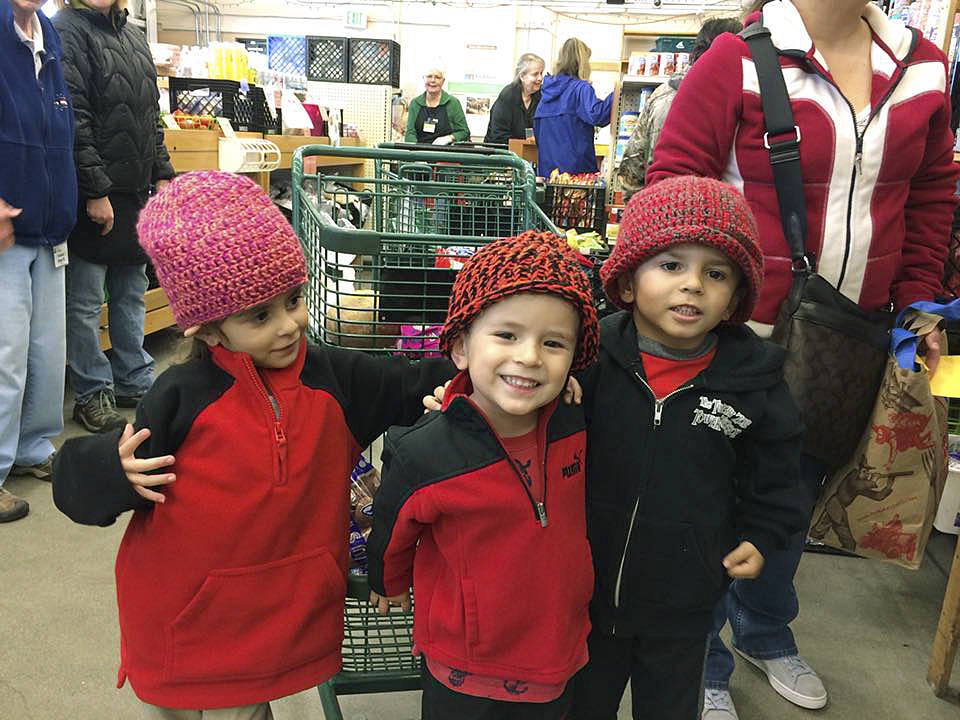 Alan, Alexa and Augustine all got to pick out new hats last week at Fishline, hand-knitted by volunteers.                                North Kitsap Fishline/Courtesy photo