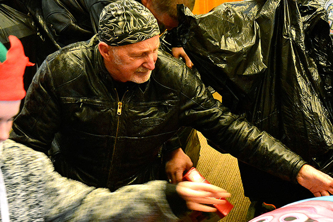 Larry Litsch, a volunteer for the North Kitsap ABATE Toy Run, unpacks a bag full of gifts. (Mark Krulish/Kitsap News Group)