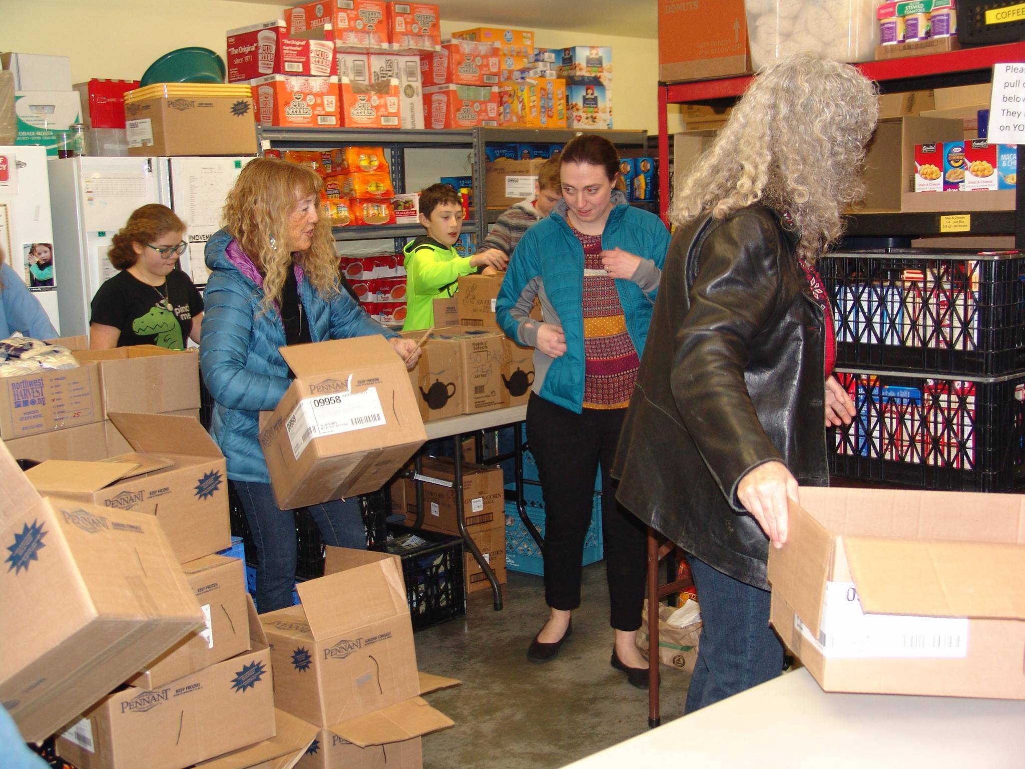Volunteers work at ShareNet’s food bank, preparing for clients to shop for groceries.                                Contributed photo