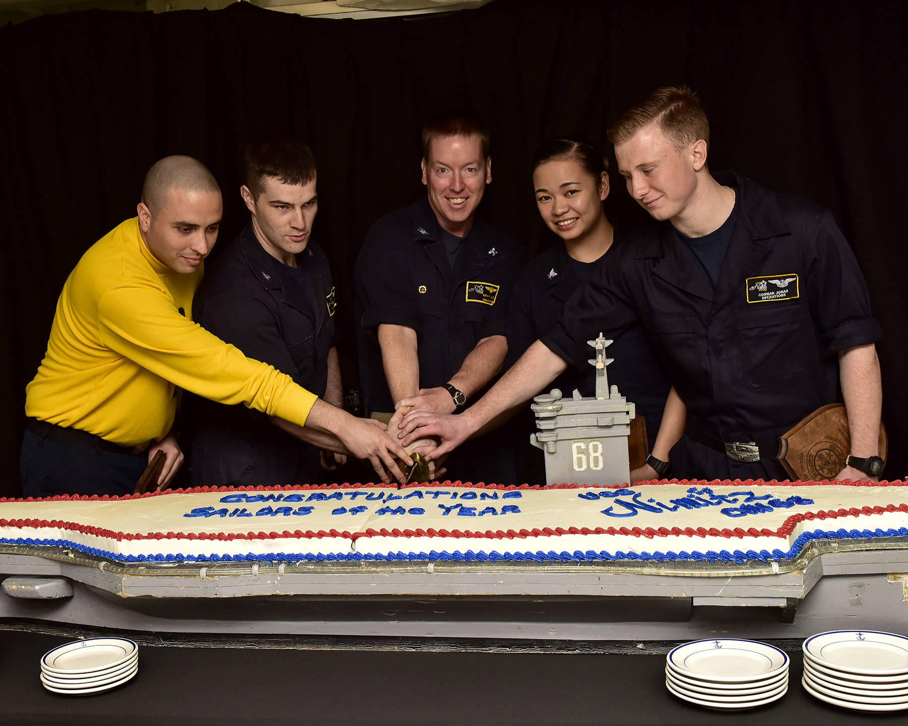 U.S. Navy sailors aboard the aircraft carrier USS Nimitz (CVN 68), cut the Sailor of the Year cake, Nov. 3 in the Sea of Japan. From left, Aviation Boatswain’s Mate (Handling) 1st Class Hugo Echeverritrujillo, Senior Sailor of the Year; Hospital Corpsman 2nd Class James Gibbens, Sailor of the Year; Capt. Kevin Lenox, commanding officer; Electronics Technician 3rd Class Dallymae Arce, Junior Sailor of the Year; Air Traffic Controller Airman Apprentice Connor Jonas, Blue Jacket of the Year. (Mass Communication Specialist Seaman Emily Johnston/U.S. Navy)