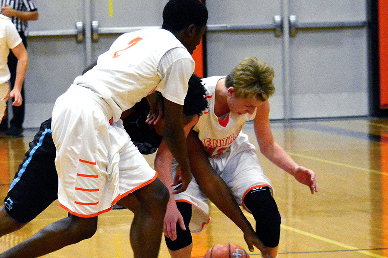 Central Kitsap’s Zion Archer and Colby White battle Gig Harbor’s Malik Livingston for a loose ball in a Dec. 8 league contest. The Tides won 58-54. (Mark Krulish/Kitsap News Group)