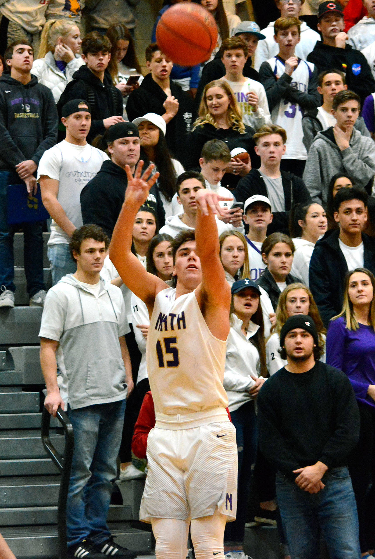 With the crowd behind him, North Kitsap’s Ryan Hecker launches a 3-point attempt against Olympic. The Vikings won the game 63-43. (Mark Krulish/Kitsap News Group)