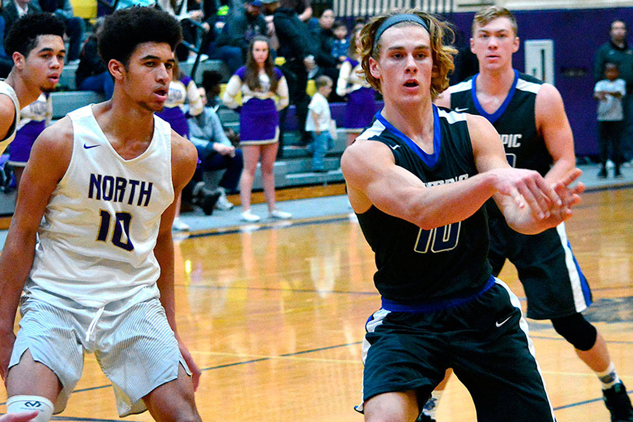 &lt;em&gt;Olympic’s Evan Turnquist dishes off to a teammate as North Kitsap’s Kai Warren (left) steps up to play defense.&lt;/em&gt;                                Mark Krulish/Kitsap News Group