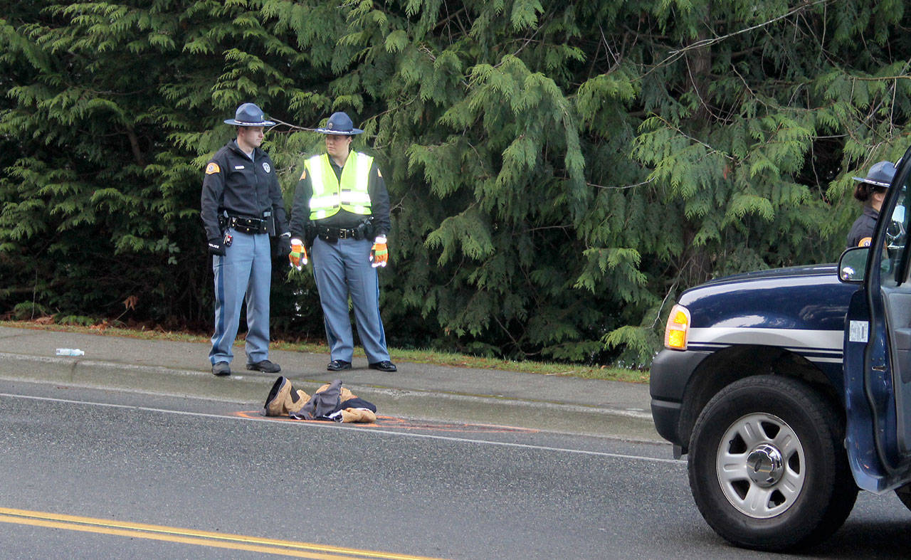 Troopers consult at the site where a woman was struck by a car, Dec. 15 in the crosswalk at Front Street and Torval Canyon Road. (Richard Walker/Kitsap News Group)