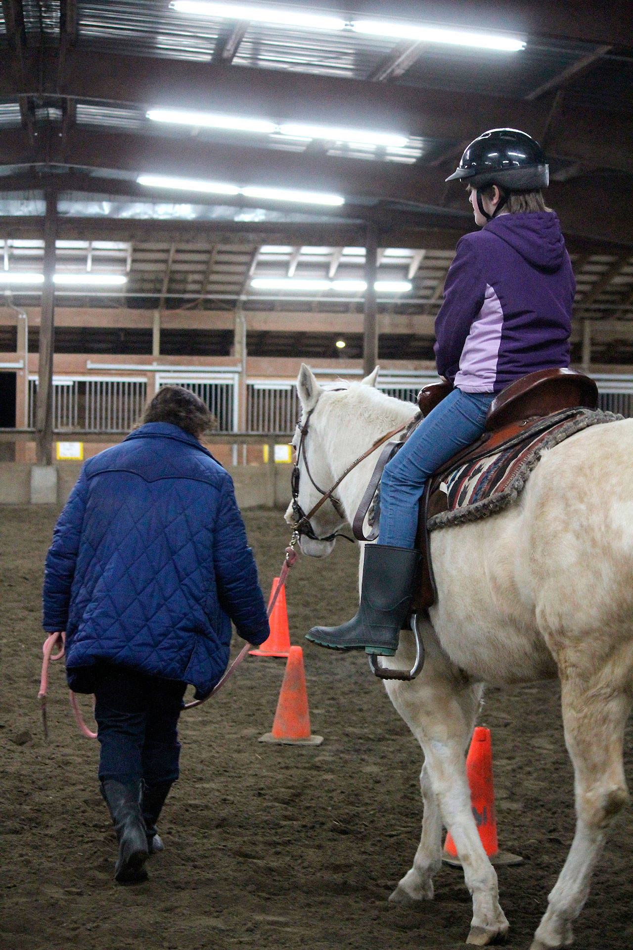 Trainers from The Riding Place led horses ridden by the foster children, some of whom had never seen a horse in person before the Dec. 22 event.                                Michelle Beahm / Kitsap News Group