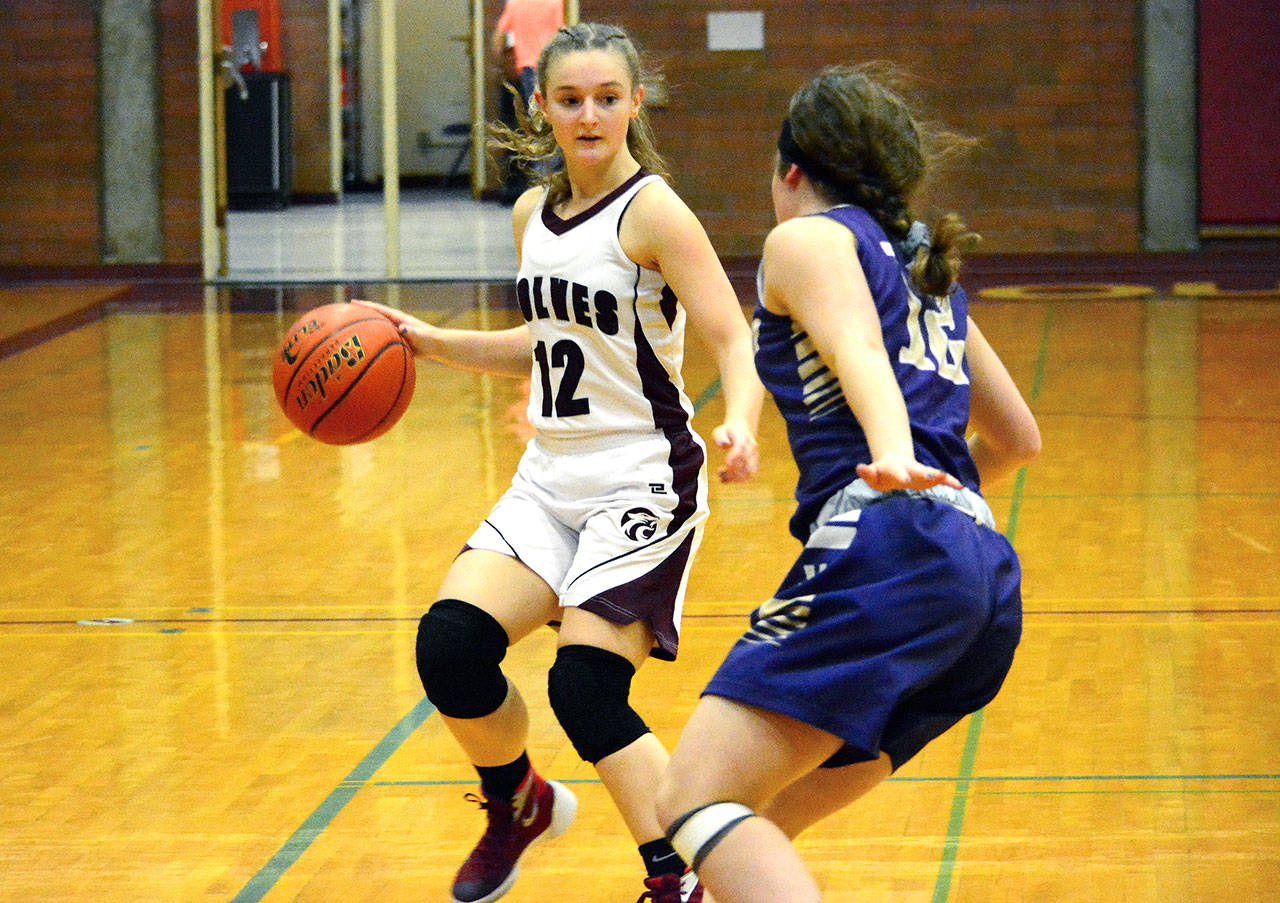 Hailey Standridge (12) looks to dribble past Puyallup’s Grace Marvin. Standridge scored 20 points in the victory over the Vikings. (Mark Krulish/Kitsap News Group)