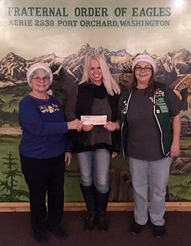 Charol Riedel and Debra Davies of the Port Orchard Eagles Club presented a check of $3,500 to Jennifer Hardison of Helpline (center) to help the organization feed hungry community members and provide Christmas gifts for needy children. (Courtesy photo)