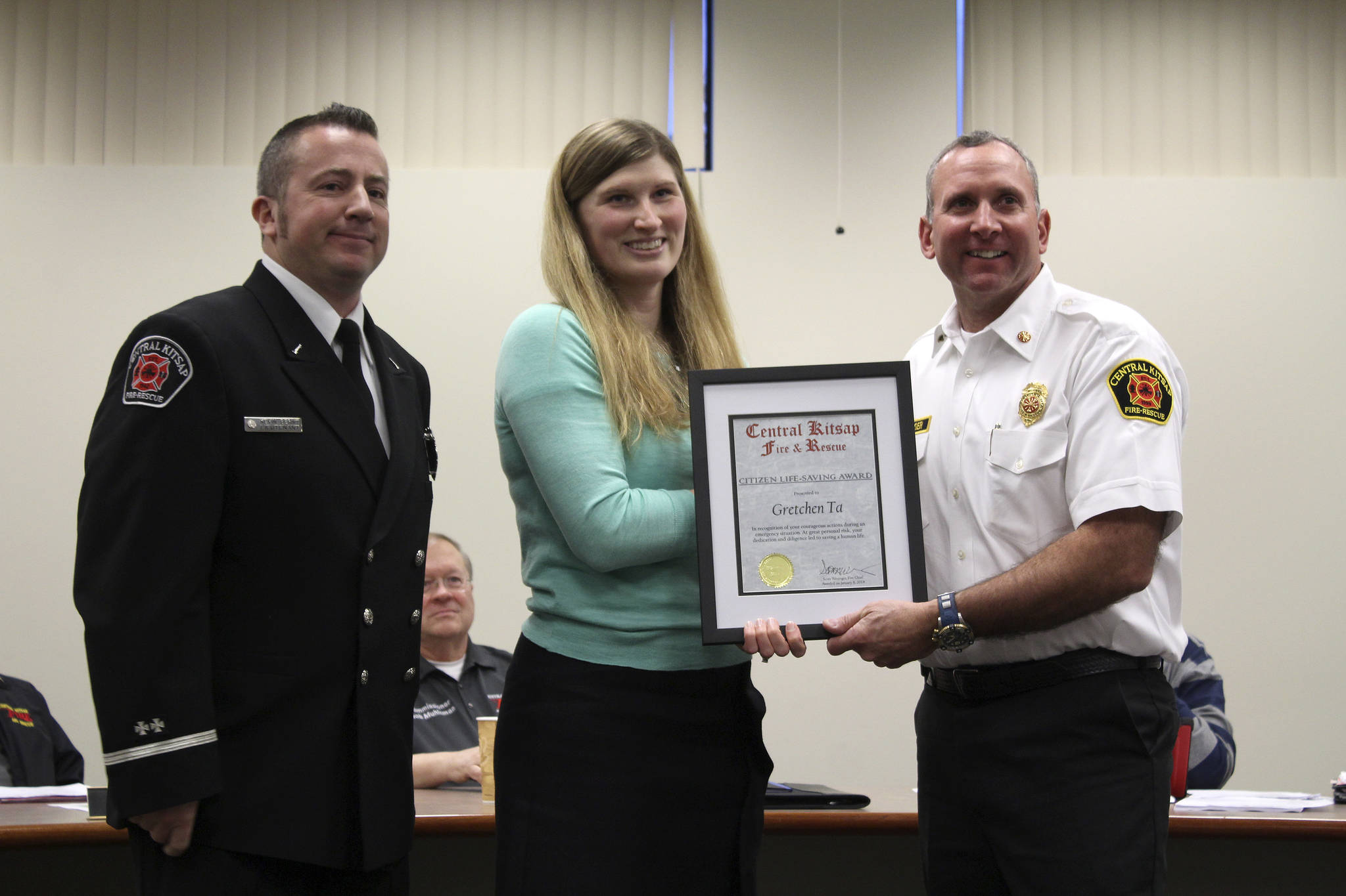 Gretchen Ta receives a Citizen Life-Saving Award from CKFR Lt. Kevin Bernt, left, and Chief Scott Weninger.                                Michelle Beahm / Kitsap News Group