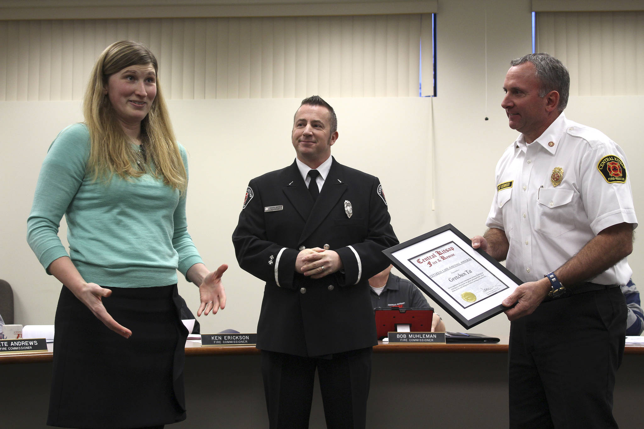 Gretchen Ta receives a Citizen Life-Saving Award from CKFR Lt. Kevin Bernt, left, and Chief Scott Weninger.                                Michelle Beahm / Kitsap News Group