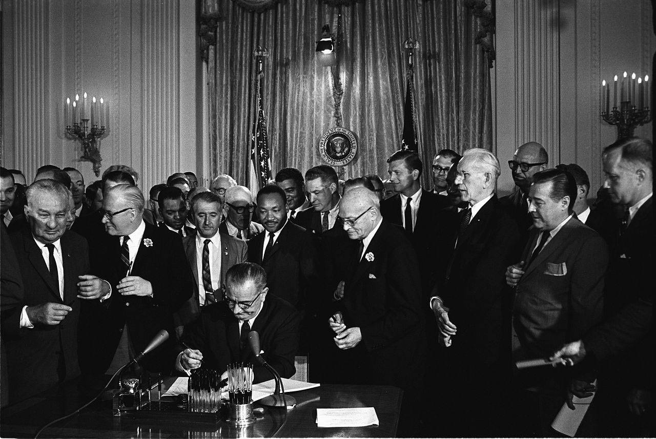 President Lyndon B. Johnson signs the 1964 Civil Rights Act as Martin Luther King Jr. and others look on.(Cecil Stoughton, White House Press Office/Public domain)