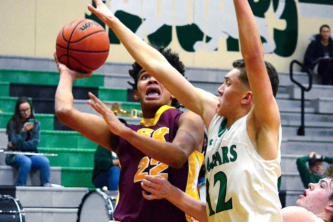 DeAnte Ward (22) drives the lane against the Emerald Ridge defense. Ward scored 23 points, but South Kitsap lost 58-54.                                 Mark Krulish                                Kitsap News Group