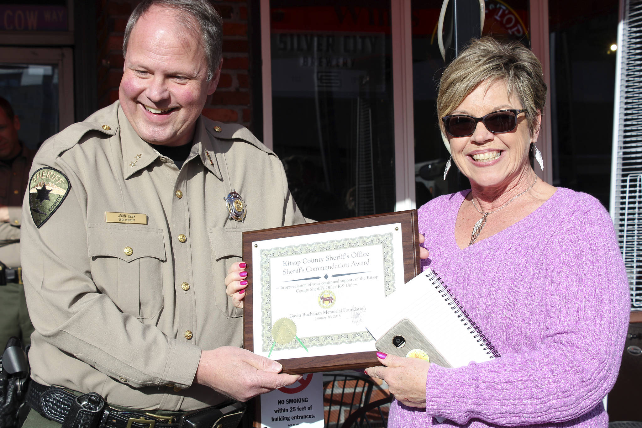 Kitsap County Sheriff’s Undersheriff John Gese presents Bill and Susie Slankard with a KCSO Commendation award. (Michelle Beahm | Kitsap Daily News)