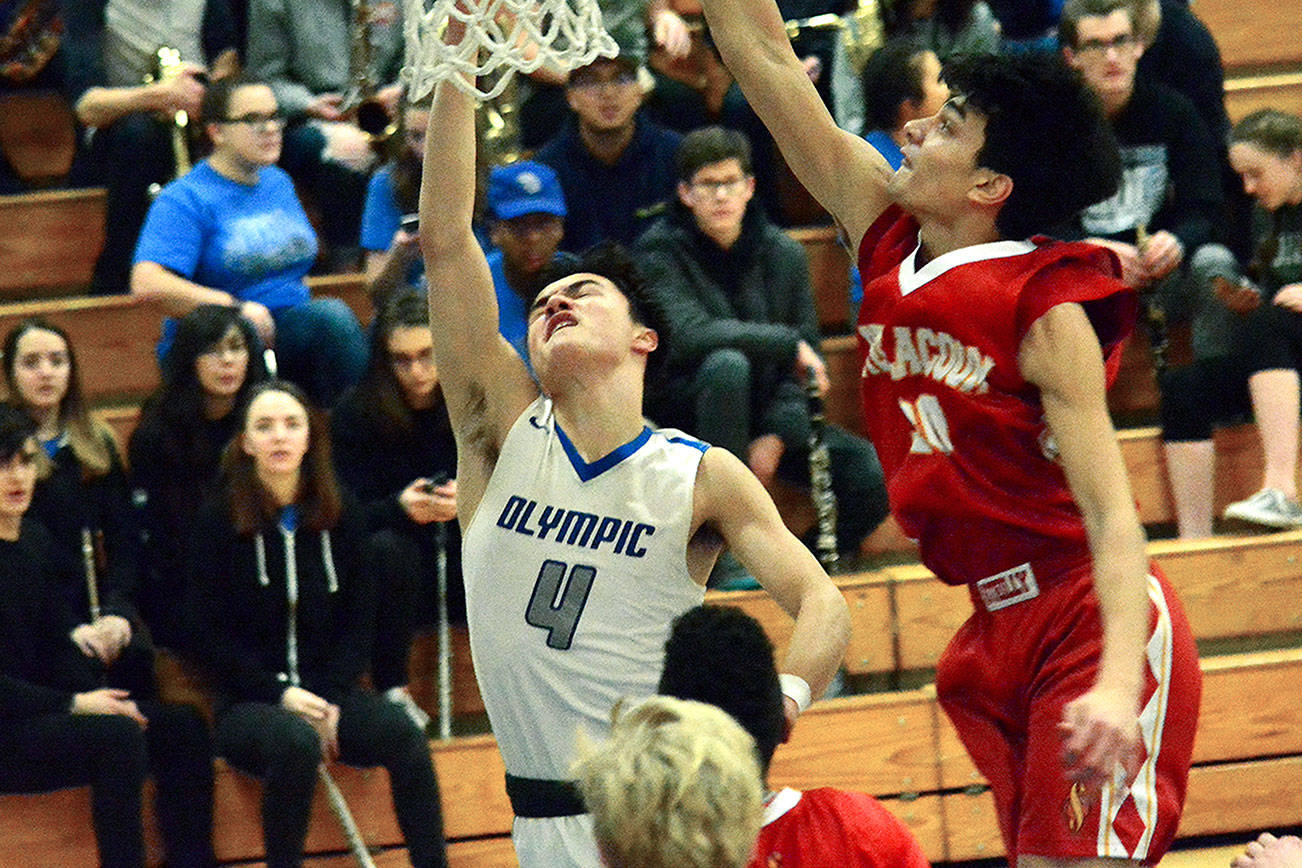 Olympic’s Brandon Barron (4) scores a layup as Giovanni Vasquez attempts the block. The Trojans defeat the Sentinels, 50-39 on Feb. 8 in the West Central District 2A tournament. (Mark Krulish/Kitsap News Group)