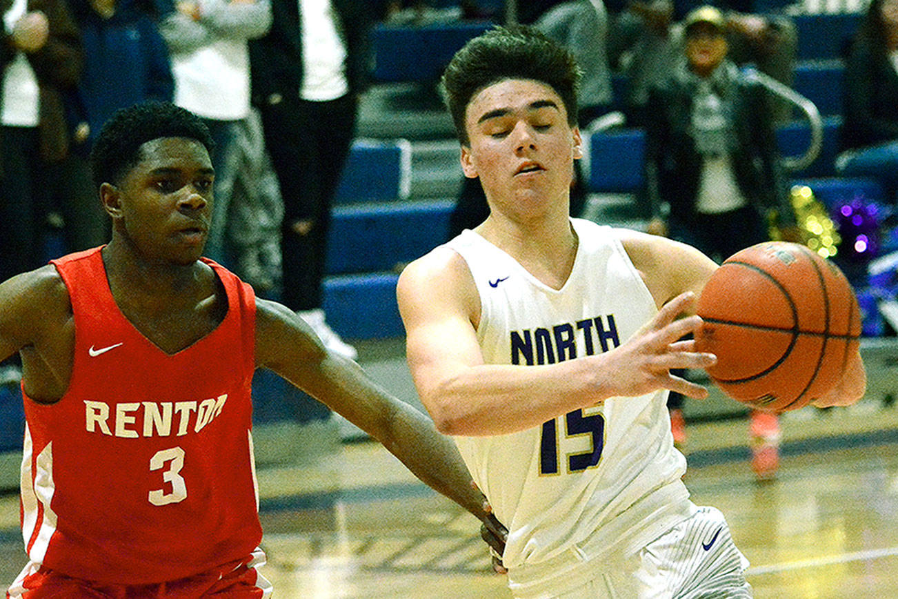 North Kitsap’s Ryan Hecker looks to get by Renton’s Jaloni Gardner. The Vikings won their district semifinal game 73-66 and will play for the championship Saturday against Fife. (Mark Krulish/Kitsap News Group)