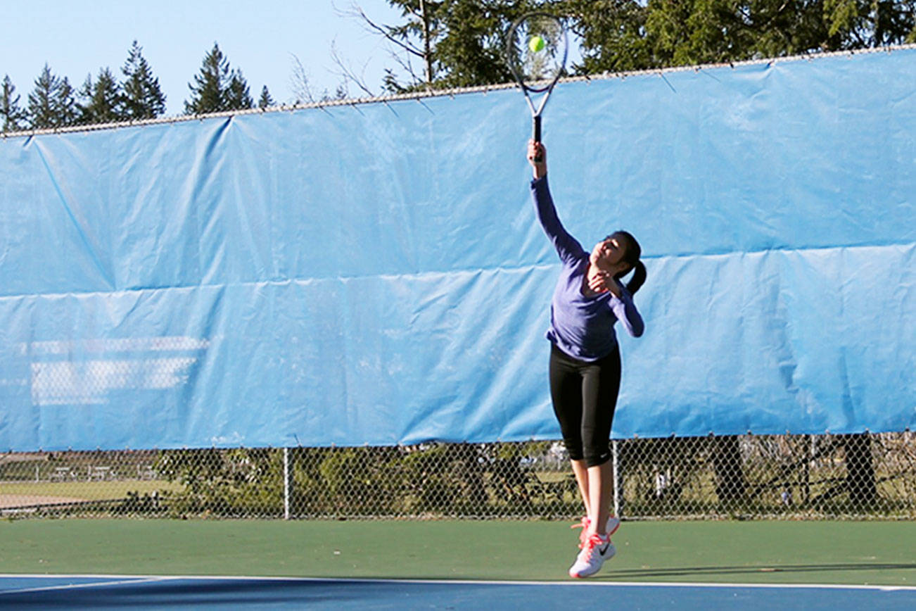 Junior Sydney Troy, right, watches as senior Brooklyn Haro serves the ball in a March 6 practice at the Olympic High School tennis courts. Haro and Troy went to state last year as a doubles team. Jacob Moore | Kitsap News Group