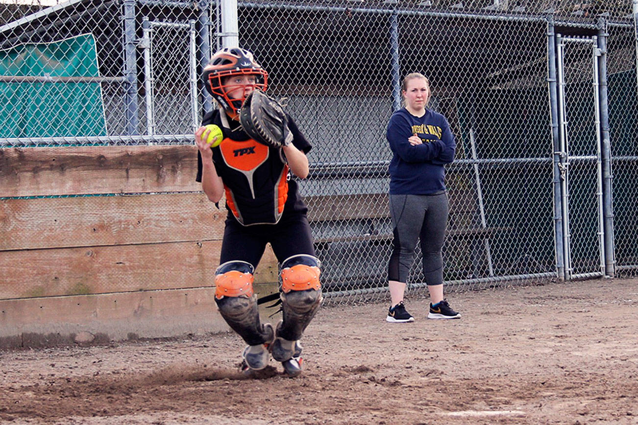Senior catcher Calli Frisinger hops and throws the ball toward first base in a practice drill at Linder Softball Field on March 12.