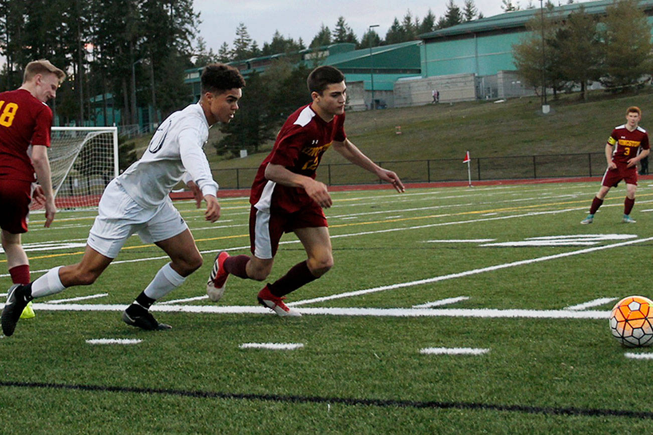 Kingston junior defender Davey Anderson, right, and Klahowya senior forward Darius Joe battle for the ball during the first half of their March 19 game. The Buccaneers won 2-1. Jacob Moore | Kitsap News Group