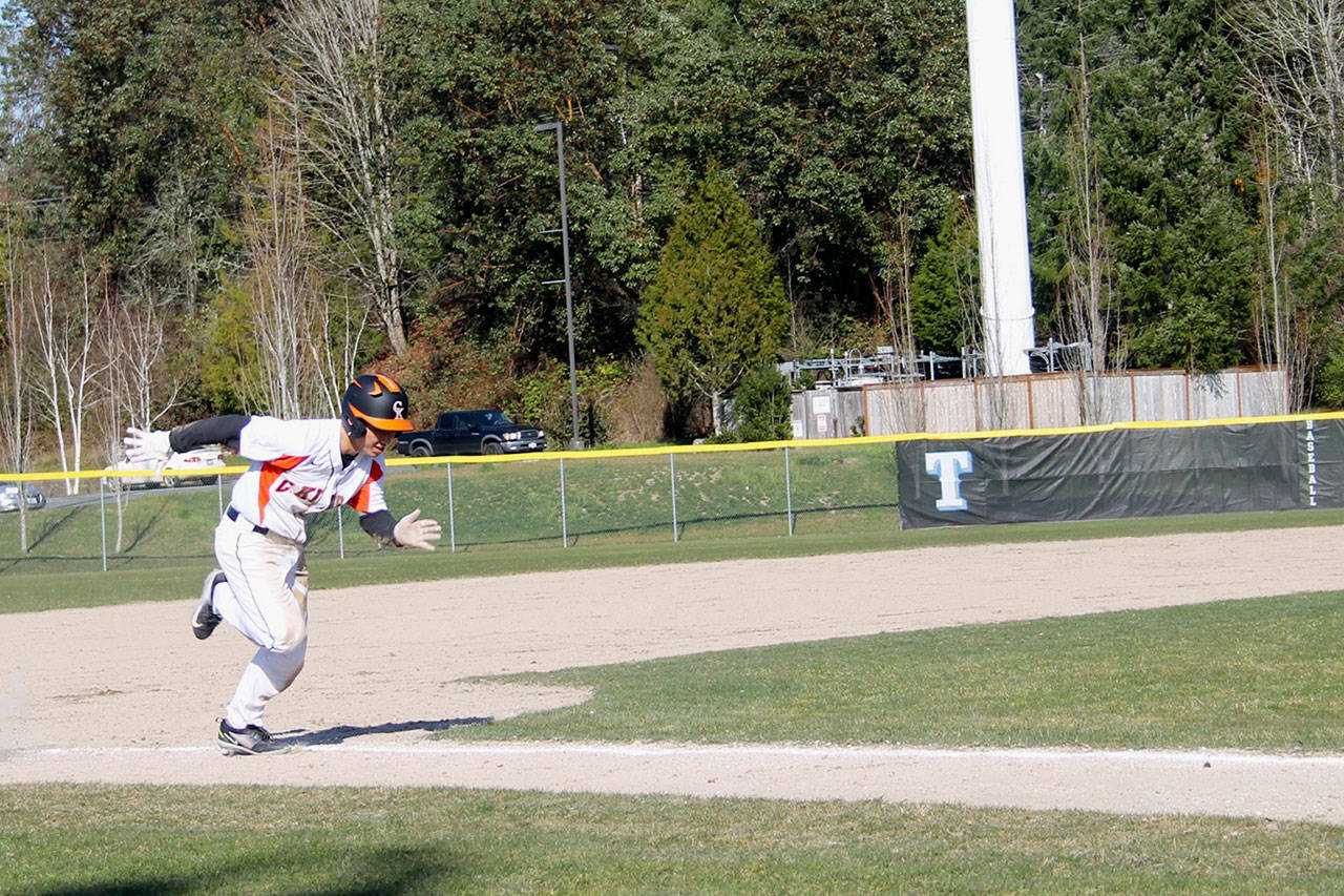 The Cougars’ Fred Buckson races home in the first inning of the game against Peninsula on March 20. He scored the first run of the game. Jacob Moore | Kitsap News Group