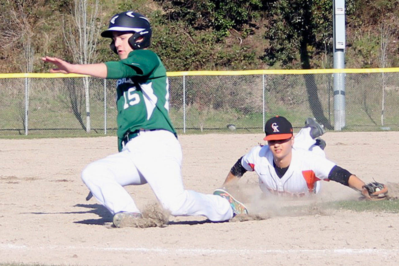 Cougars sophomore third baseman Kade Coombe dove, but missed the tag on Peninsula sophomore outfielder Peter King. Jacob Moore | Kitsap News Group