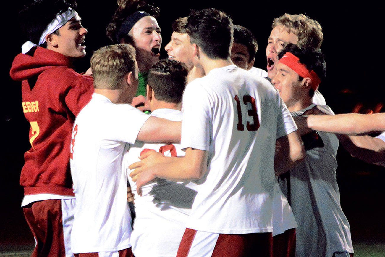 Kingston celebrates a victory over North Kitsap following a save by keeper Ian Schmid in the seventh round of the penalty shootout. (Mark Krulish/Kitsap News Group)