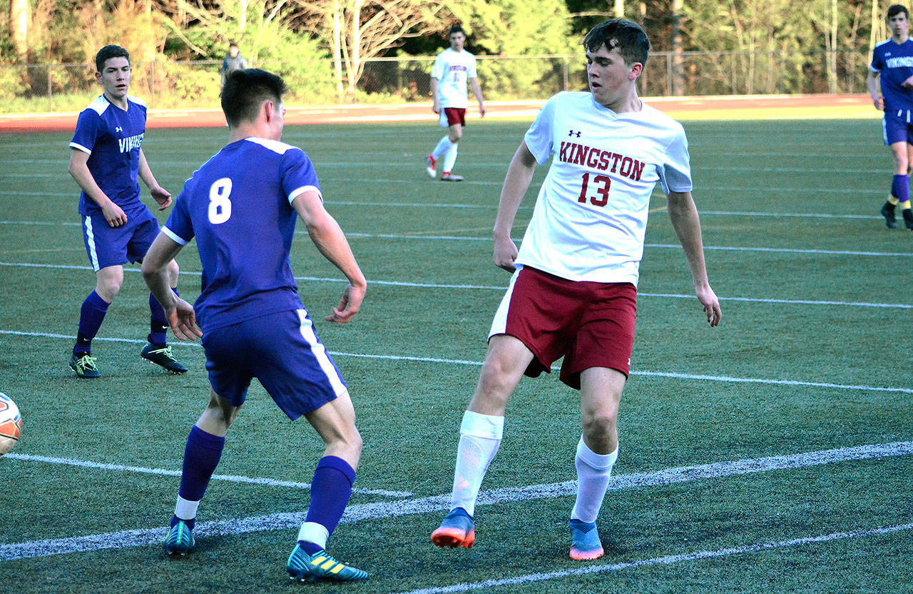 Kingston’s Bradley Walgren tries to chip the ball past North Kitsap’s Alex Bailey during the first half of the game. (Mark Krulish/Kitsap News Group)