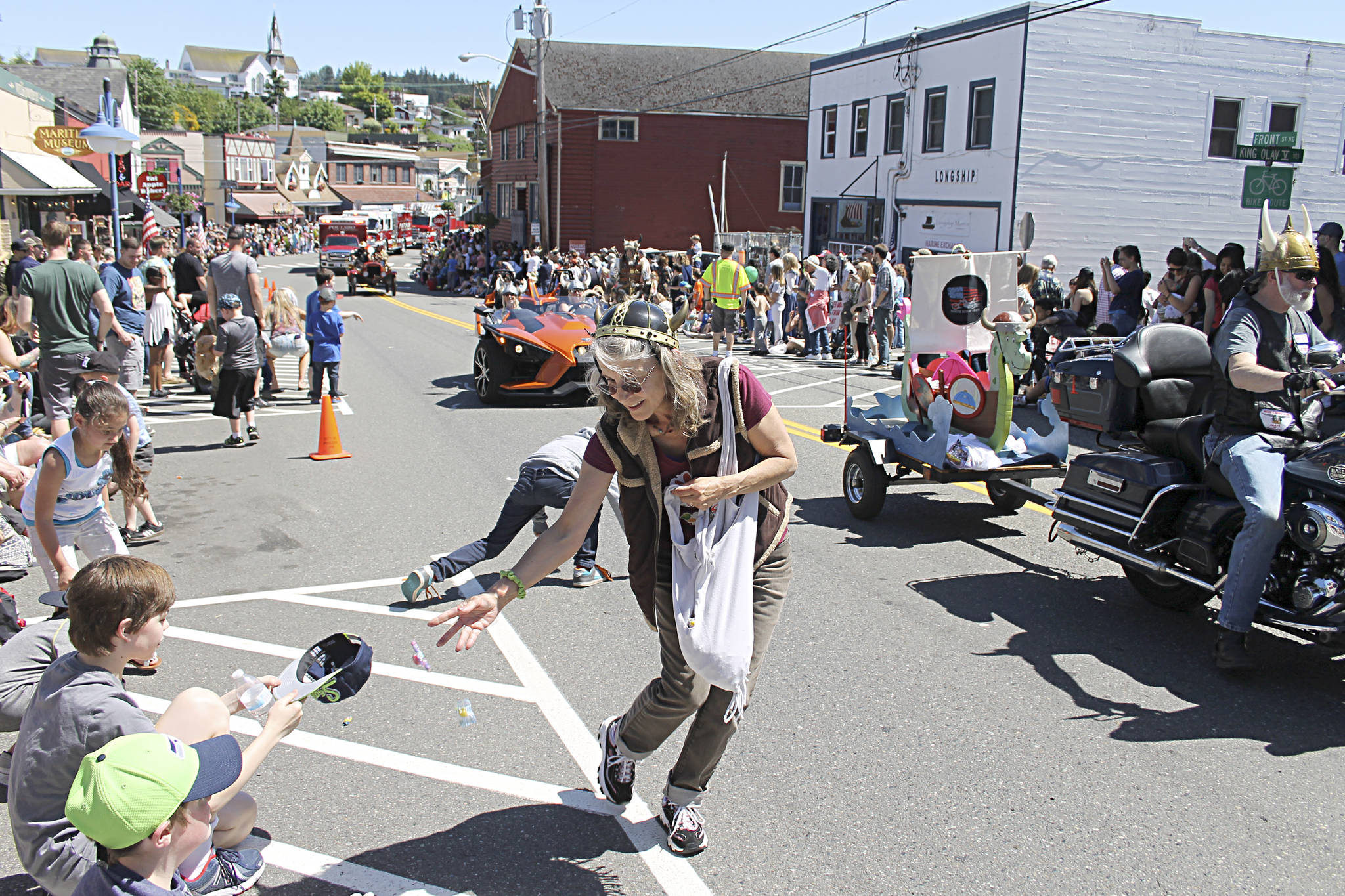 Volunteers toss candy to the crowd along the parade route during the 2017 Viking Fest Parade. Kitsap News Group