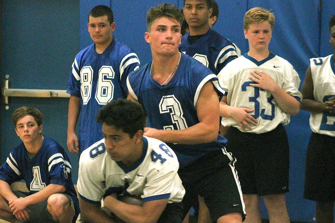 Junior quarterback Zeke Gillick hands off to his running back during an indoor practice. (Mark Krulish/Kitsap News Group)