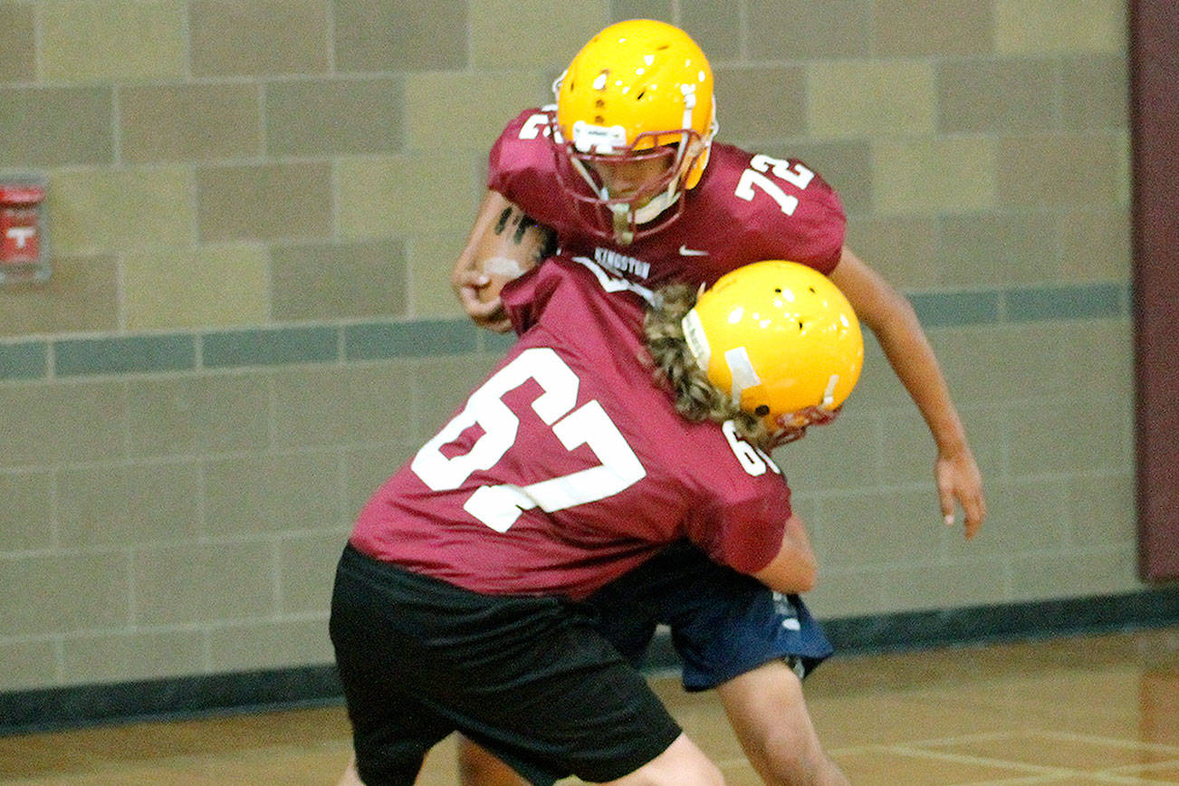 Kingston players practiced wrapping up the ball carrier — without doing any actual tackling — during an indoors practice on Aug. 21. Poor air quality has kept teams inside for the most part this season. (Mark Krulish/Kitsap News Group)