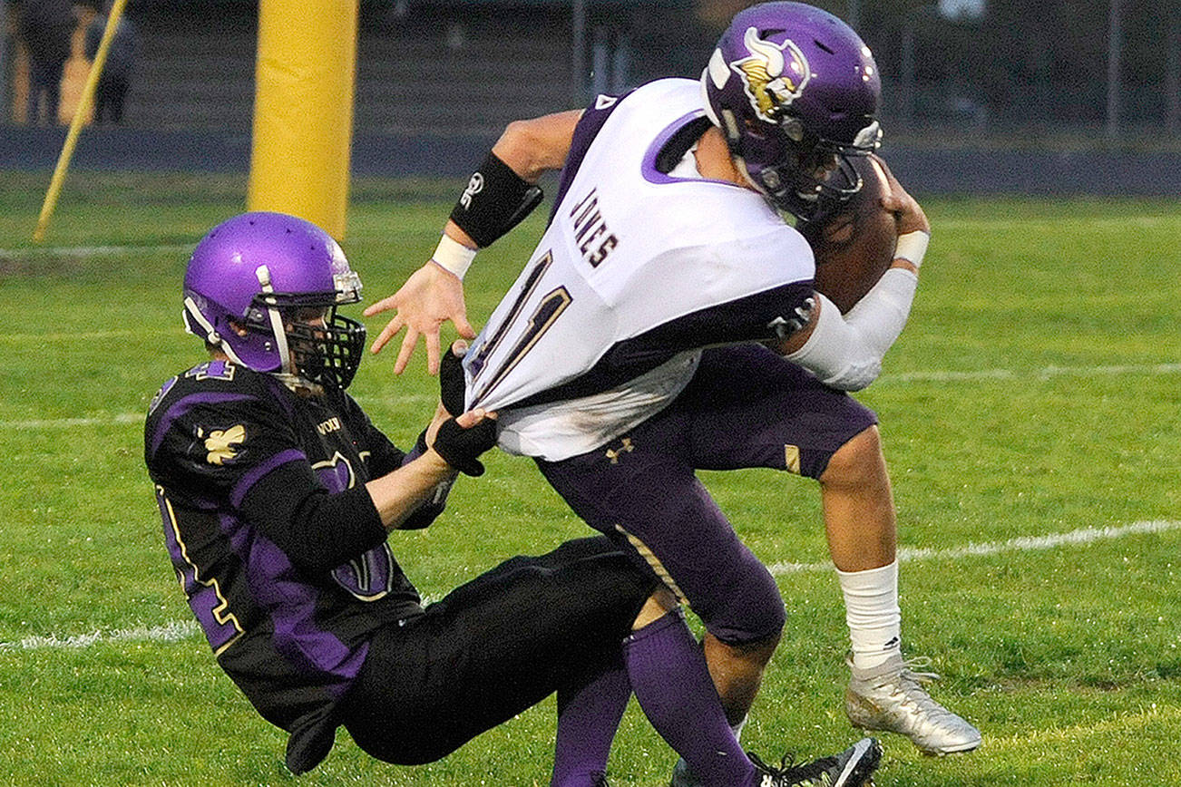 North Kitsap’s John Jones gets his jersey pulled by a Sequim defender. (Michael Dashiell/Olympic News Group)